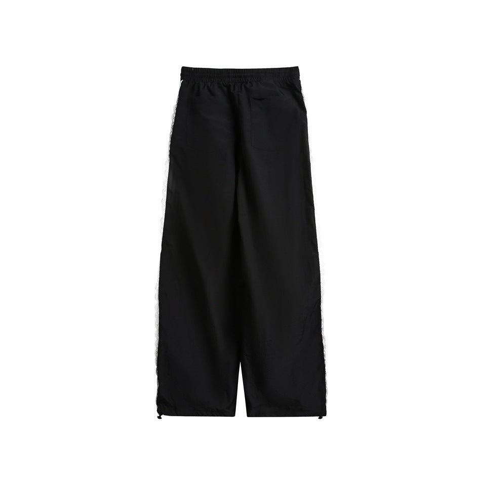 Back view of black wide-leg pants with elastic waist, back pocket, lace side trim and hem drawcords