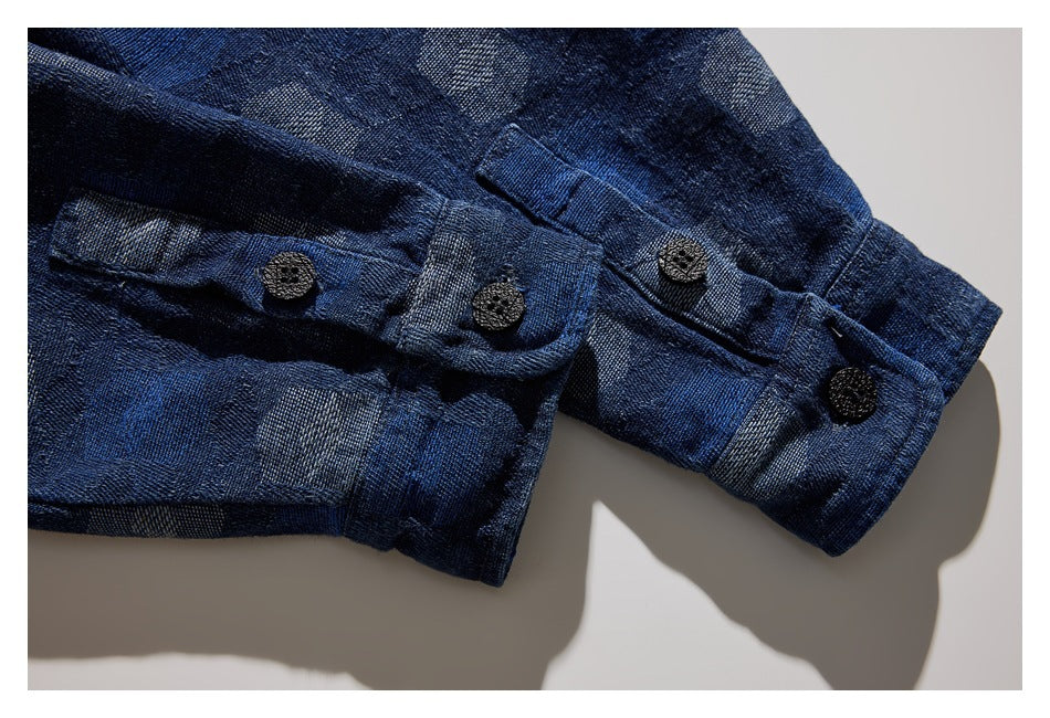 Close-up of the dark blue patterned shirt cuff with a buttoned strap and black buttons.