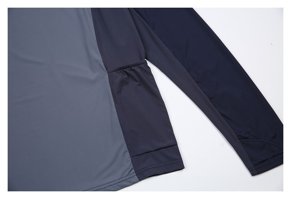 Close-up of a gray and navy long-sleeve top showing contrasting sleeve panels and stitching.