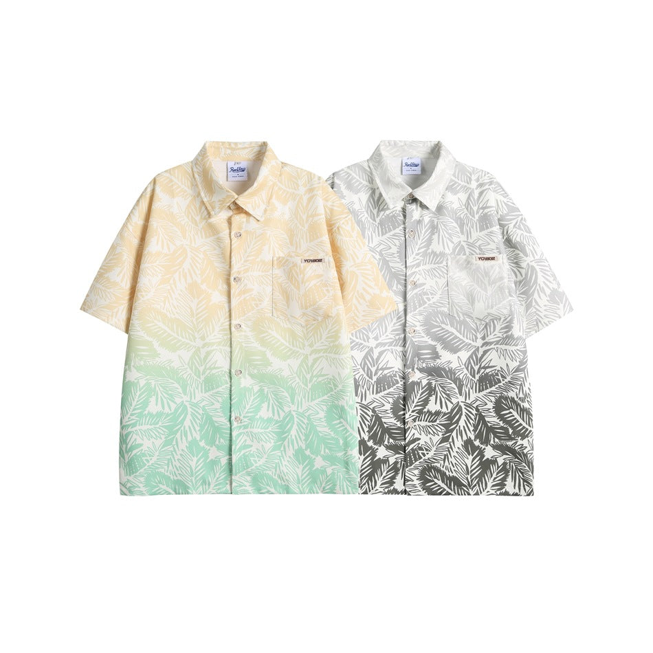 Two short-sleeve tropical leaf print shirts: one yellow fading to mint green, and one gray and white.
