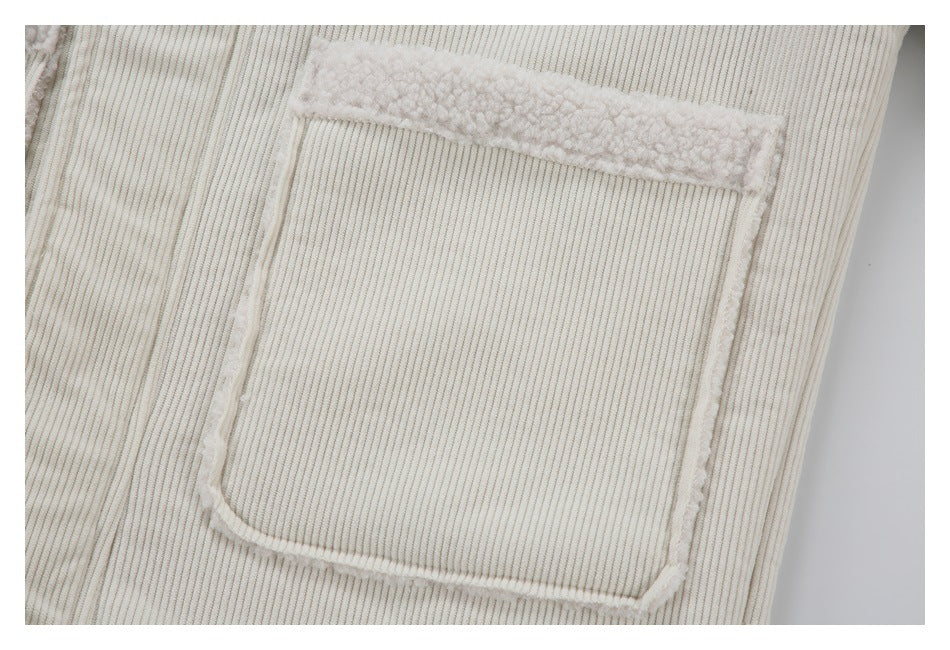 Close-up of a square patch pocket with fuzzy edging on ivory ribbed fabric.
