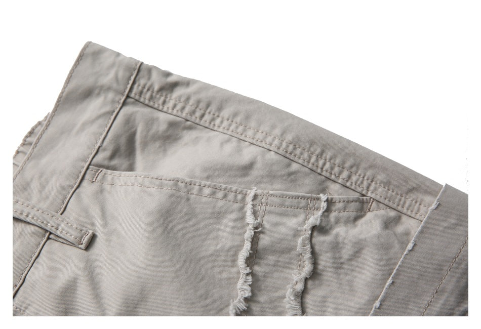 Close-up of the light taupe trousers' waistband, belt loop, and distressed pocket detail.