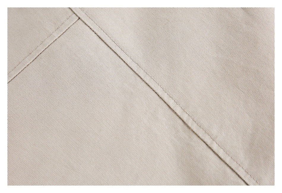 Close-up of a diagonal seam across beige garment fabric.