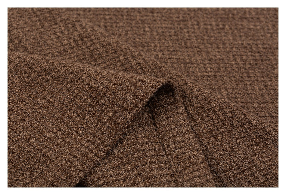 Close-up of brown knit fabric folded to reveal its textured stitch and drape.