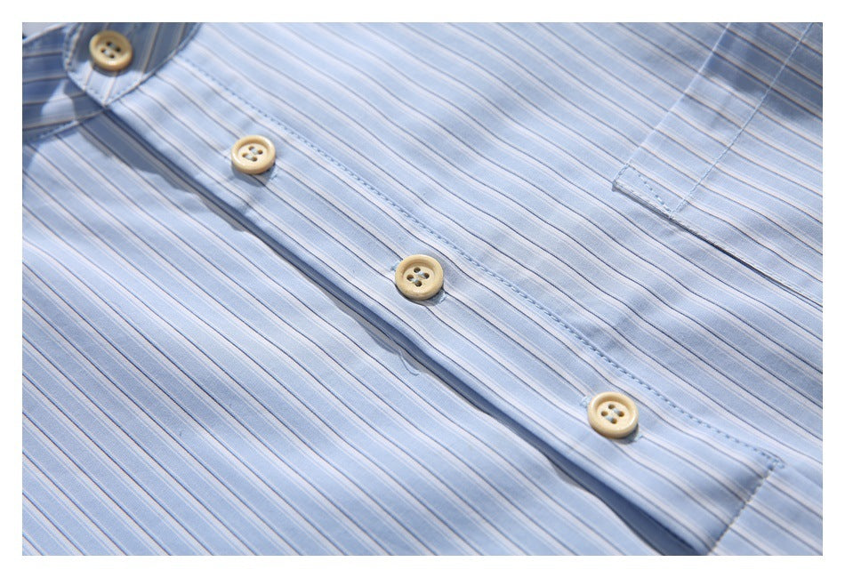 Close-up of the light blue striped shirt’s button placket and beige buttons.
