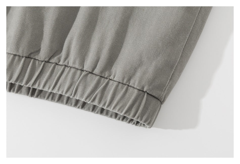 Close-up of gray garment fabric with a gathered elastic hem and stitched seam.