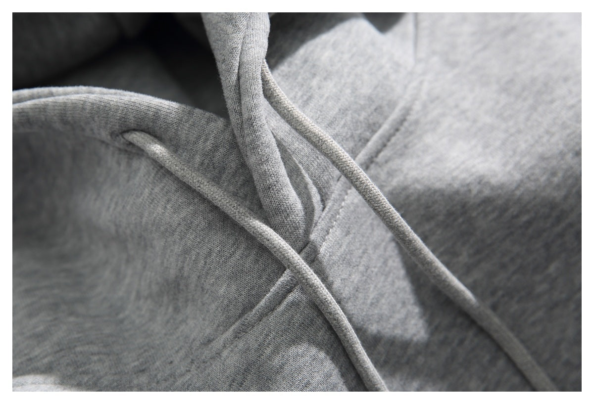 Close-up of the gray hoodie’s hood seam and matching drawstrings.
