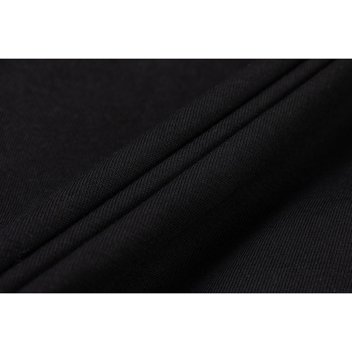 Close-up of black fabric folded to show its fine ribbed texture.