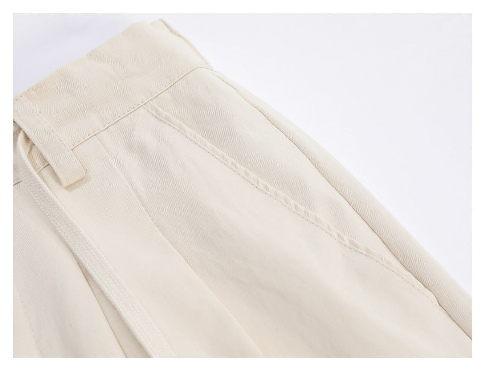 Close-up of an ivory trouser side pocket, belt loop and hanging drawstring.