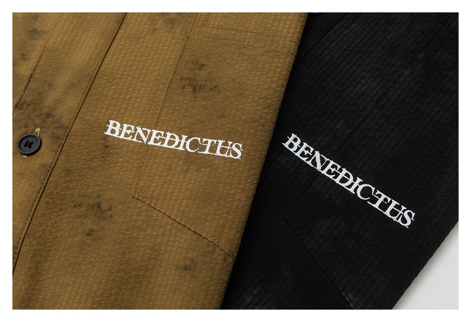 Close-up of brown and black textured shirt fronts with white BENEDICTUS lettering on the chest pockets.