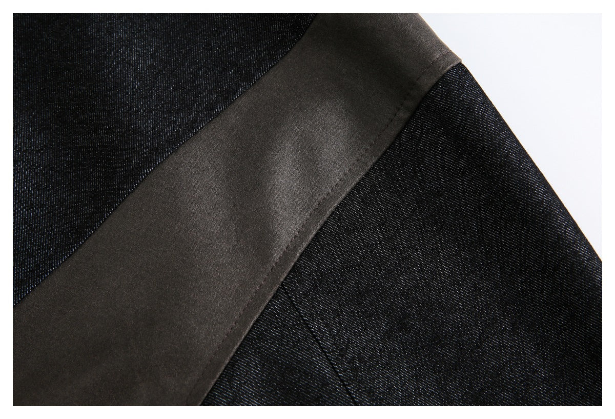 Close-up of a wide smooth dark strip crossing textured black fabric, with visible stitching.