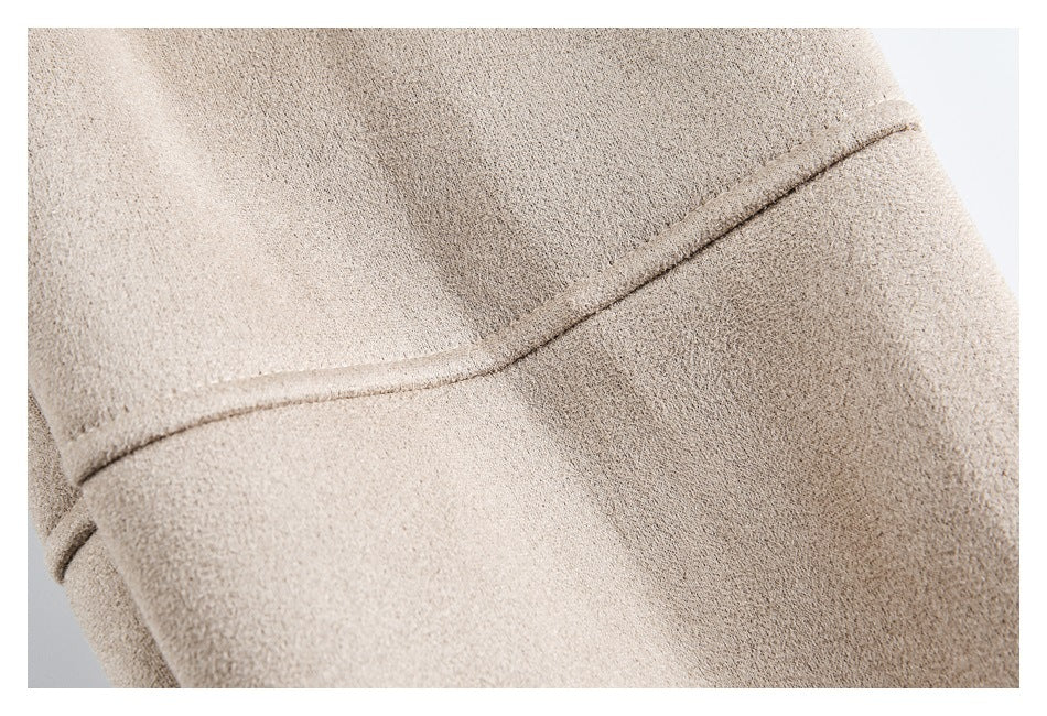 Close-up of the beige jacket's curved stitched panel seam and textured surface.