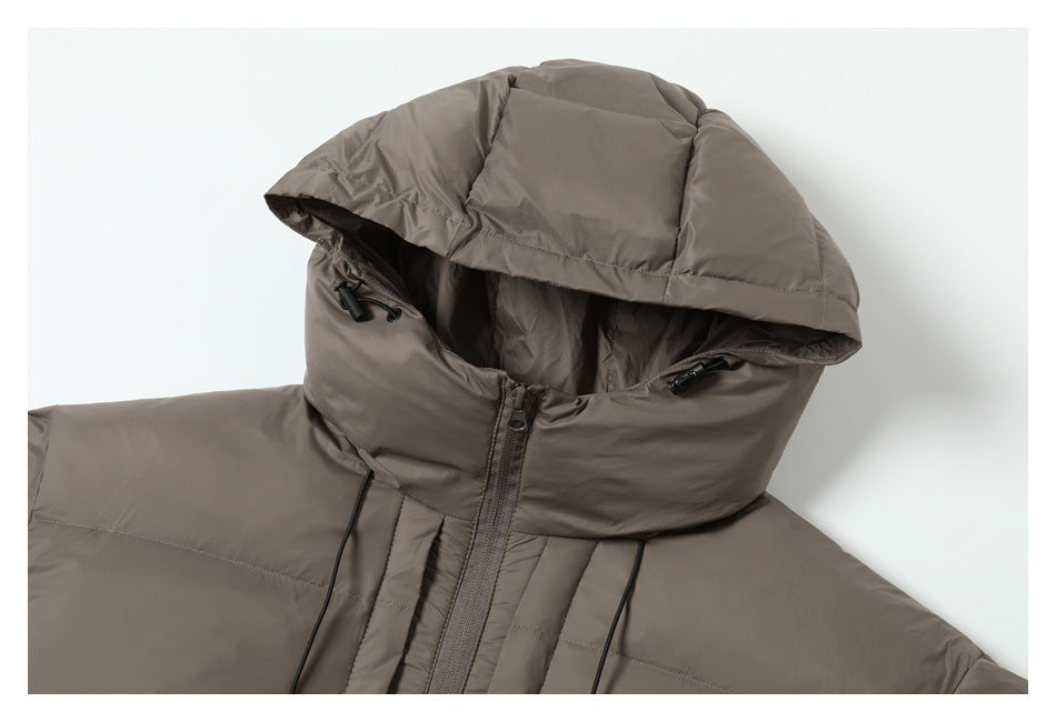 Close-up of a taupe puffer jacket’s oversized hood, drawcords, and front zipper.