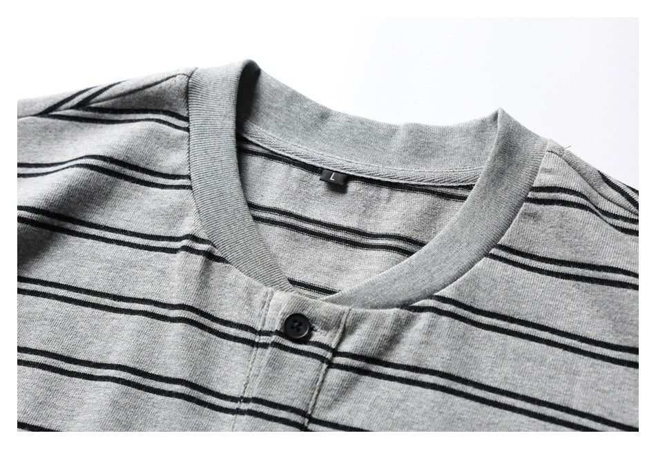 Close-up of a gray short-sleeve Henley shirt with thin black stripes, showing its neckline and single-button placket.