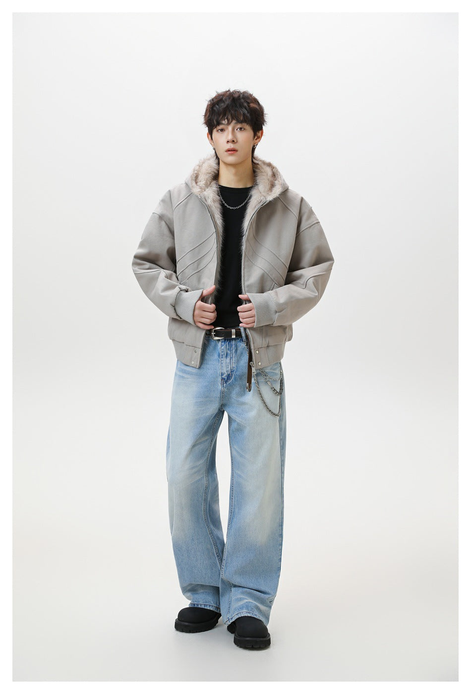 Full-length model wearing a light gray hooded jacket with plush lining, ribbed cuffs, and loose light-wash jeans.