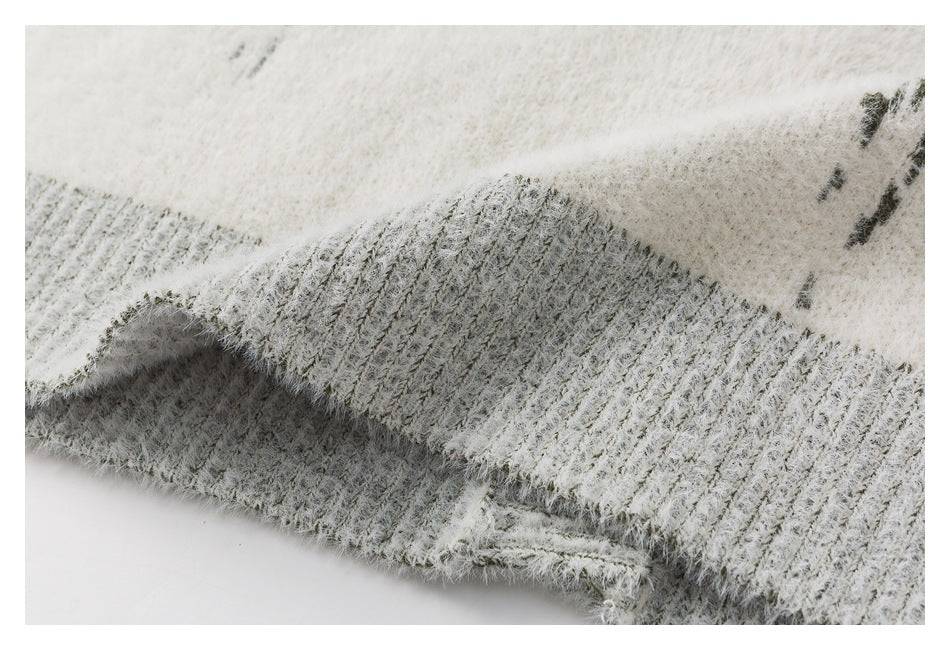 Close-up of the cardigan's gray ribbed hem and fuzzy ivory knit fabric.
