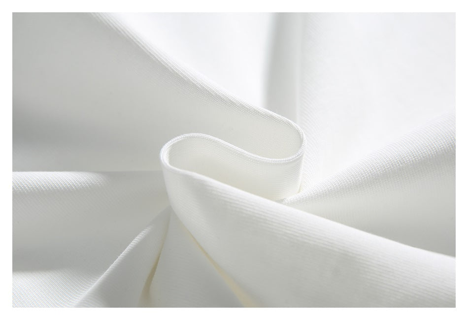 Close-up of softly folded white fabric showing its fine ribbed texture.