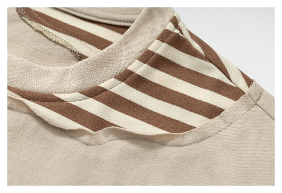Close-up showing the T-shirt's brown-and-cream striped shoulder insert and layered neckline seam.