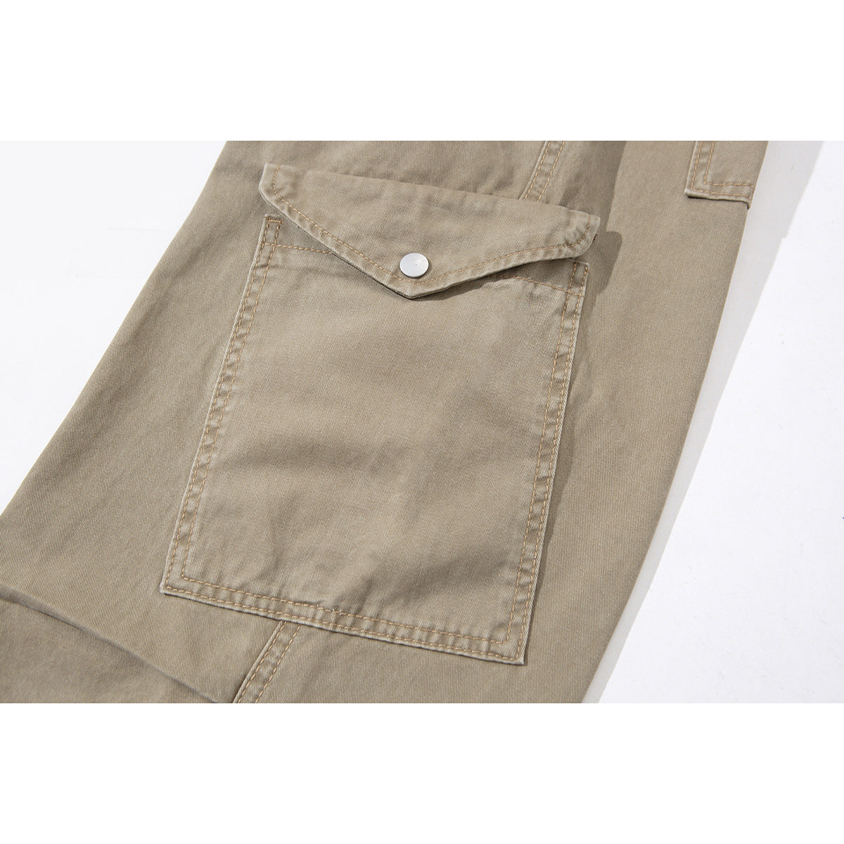 Close-up of a large taupe cargo-pant pocket with a pointed snap-button flap and visible stitching.