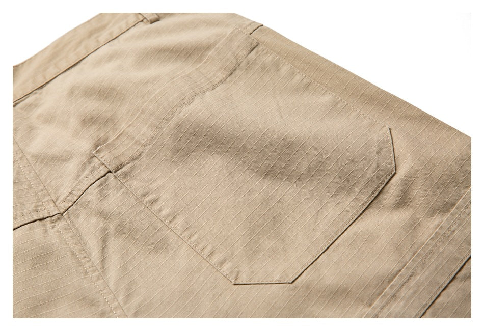 Close-up of tan trousers showing a large back pocket, stitching, and subtle horizontal fabric texture.