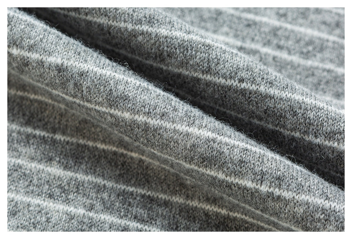 Close-up of gray knit fabric with narrow white stripes, shown in soft folds.