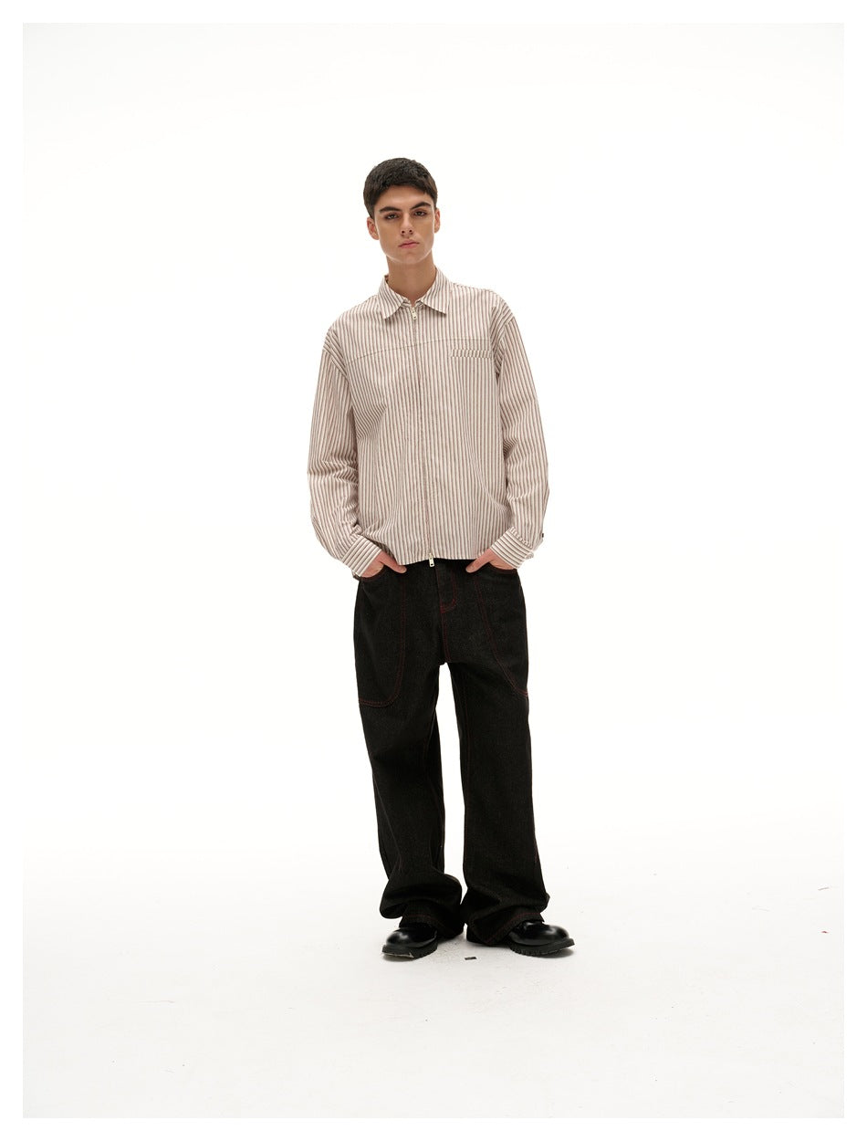 Front view of a model wearing a red-and-white pinstriped zip-front shirt and wide black jeans.