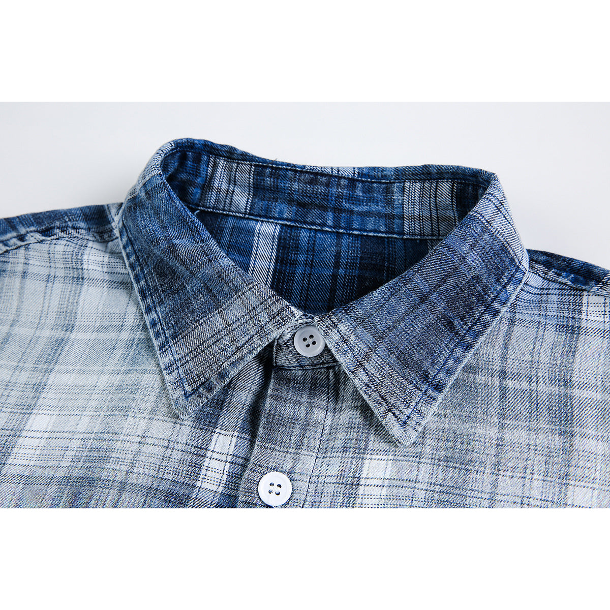 Close-up of a blue and white plaid shirt collar with white buttons.