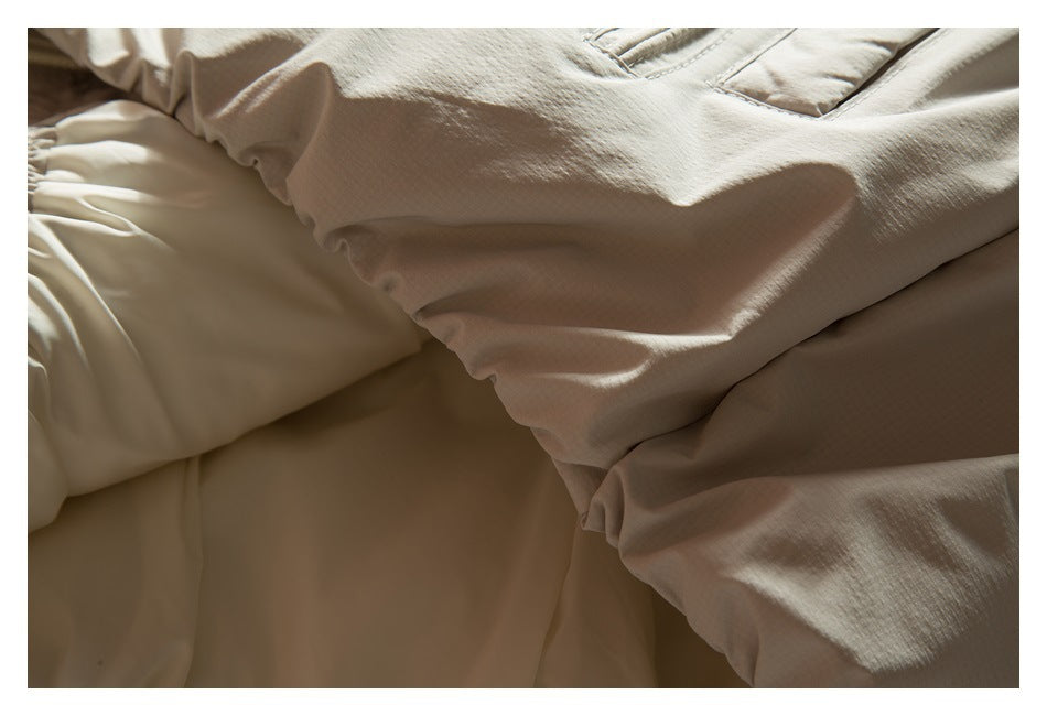 Close-up of gathered cream fabric and stitched seams on a garment.