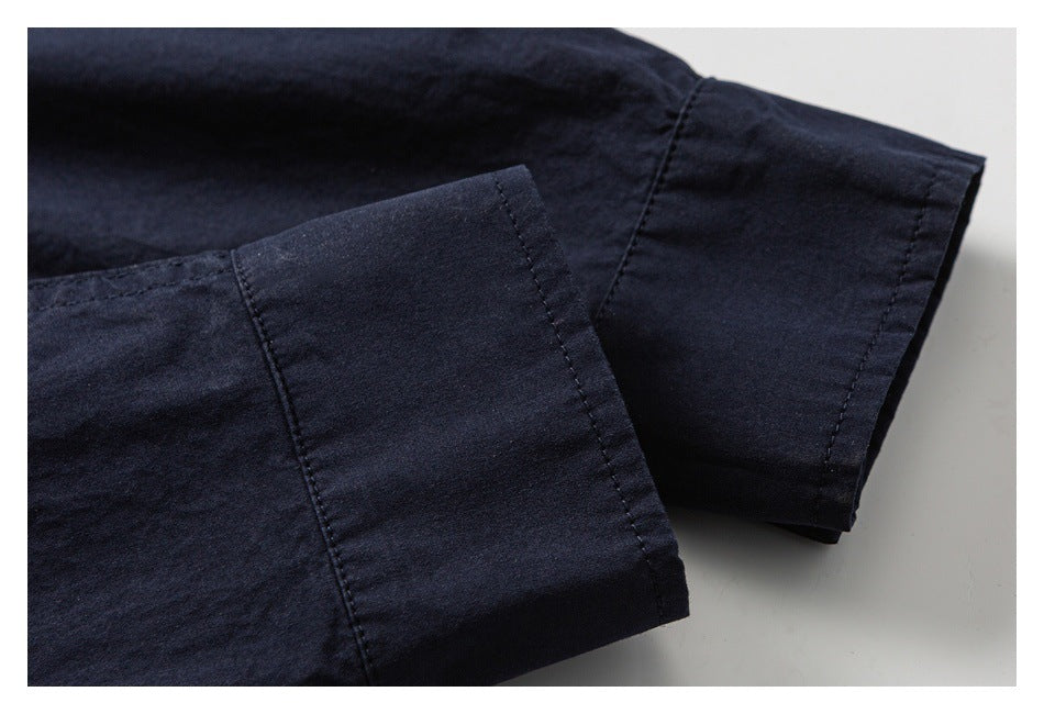 Close-up of two navy garment sleeve cuffs showing stitched hems and seams.