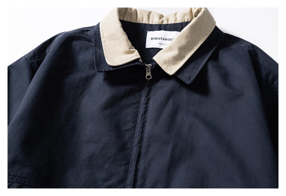 Partial front view of a navy zip-front jacket with a contrasting beige collar.