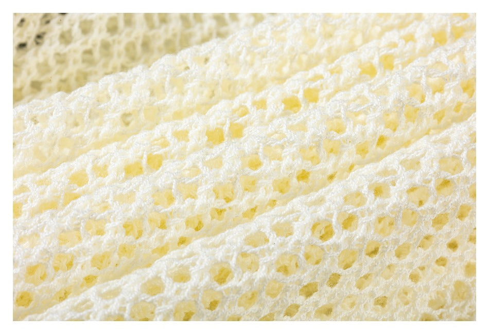 Extreme close-up of cream openwork knit showing its looped texture.