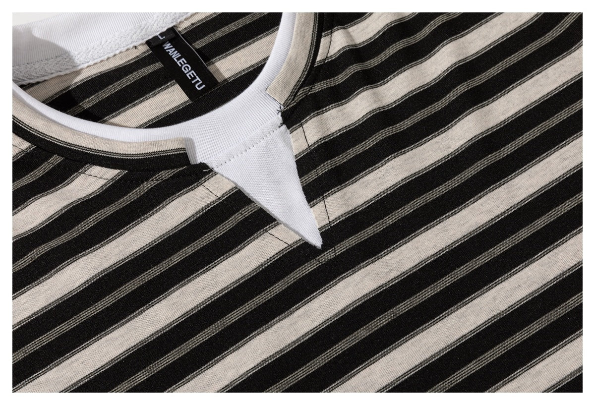 Close-up of a black and cream striped shirt neckline with white trim and a sewn-in label.