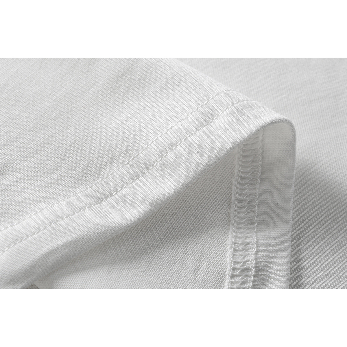 Close-up of a white T-shirt's folded hem and overlocked interior seam.