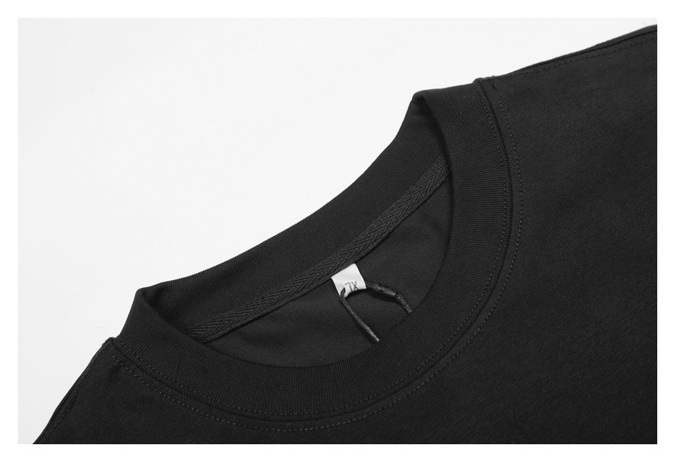 Close-up of a black shirt's ribbed crew neckline, shoulder seam and small inner tag.