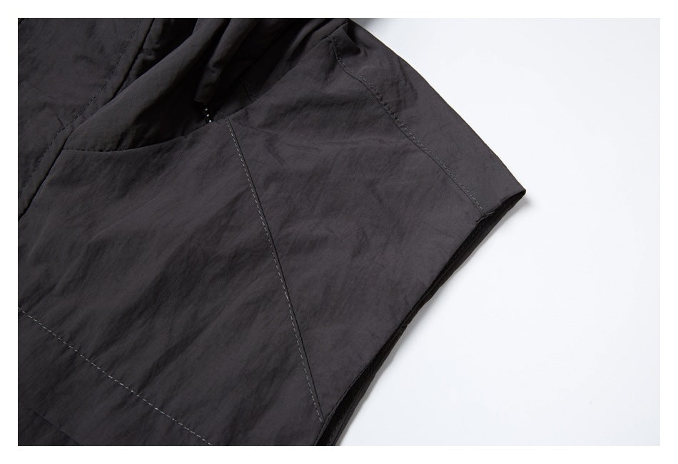 Close-up of the charcoal vest's side and armhole seams.
