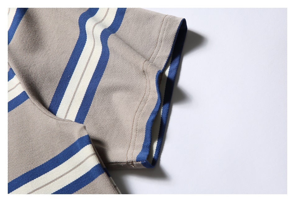 Close-up of a striped sleeve edge and stitching on the taupe T-shirt.