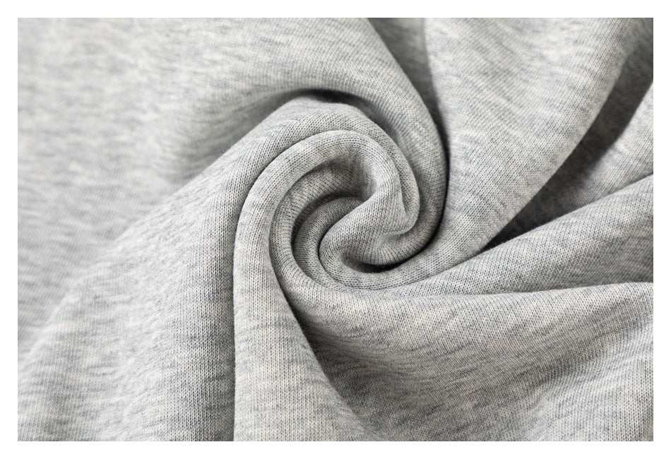 Close-up of light gray heathered knit fabric gathered into folds, showing its fine texture.