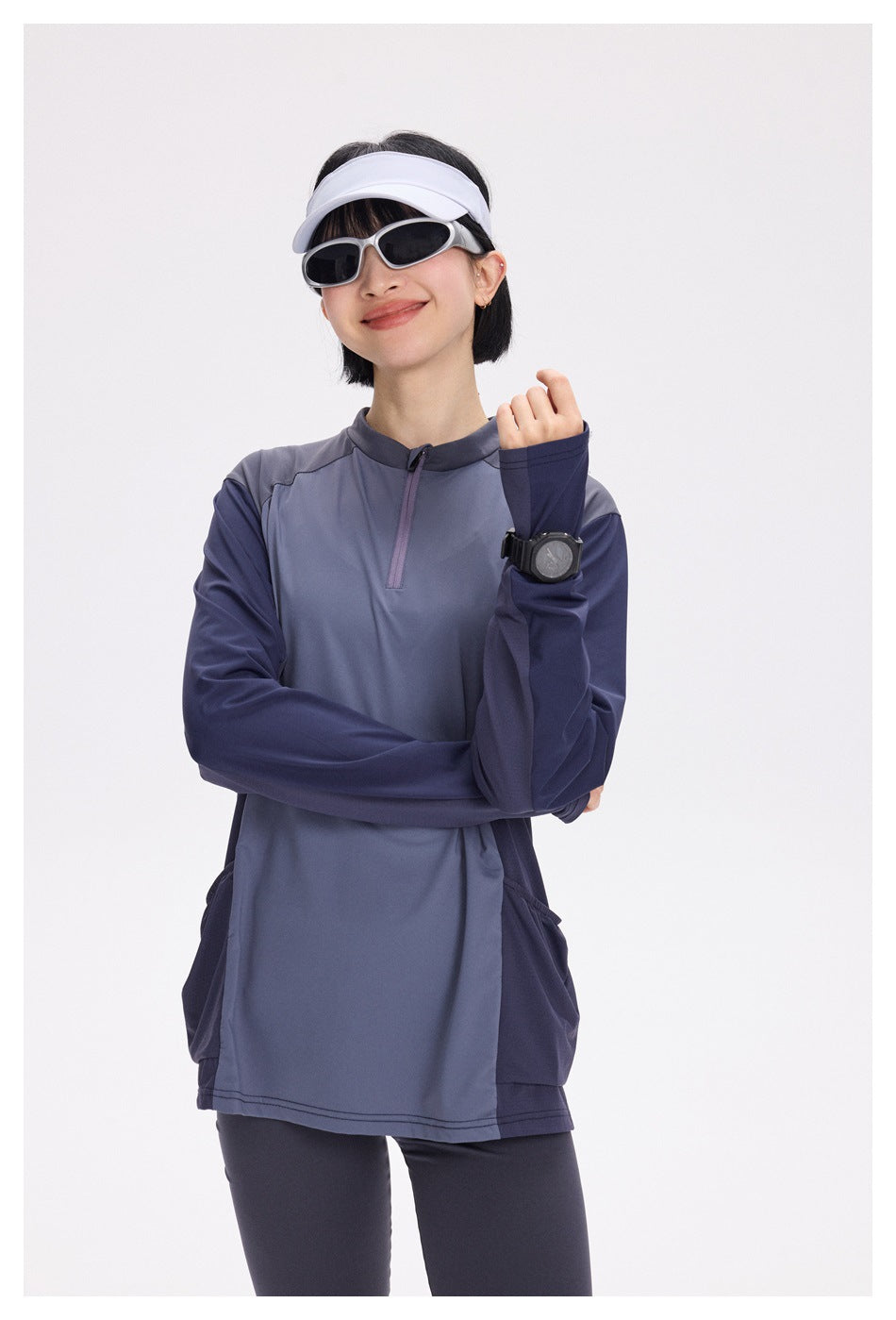 Woman modeling a slate blue and navy long-sleeve quarter-zip top with side pockets.