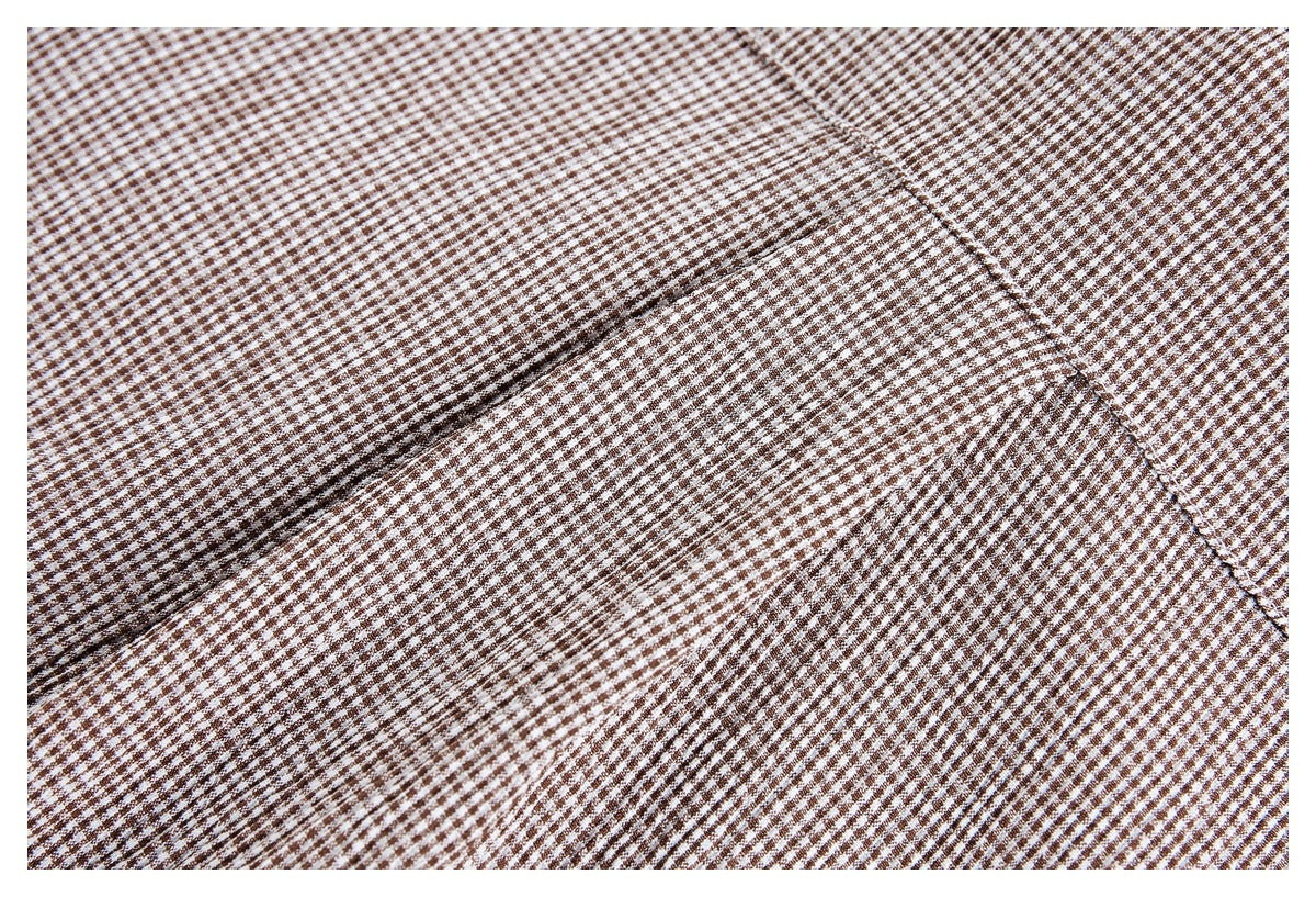 Close-up of a curved stitched seam on brown-and-white small-check fabric.