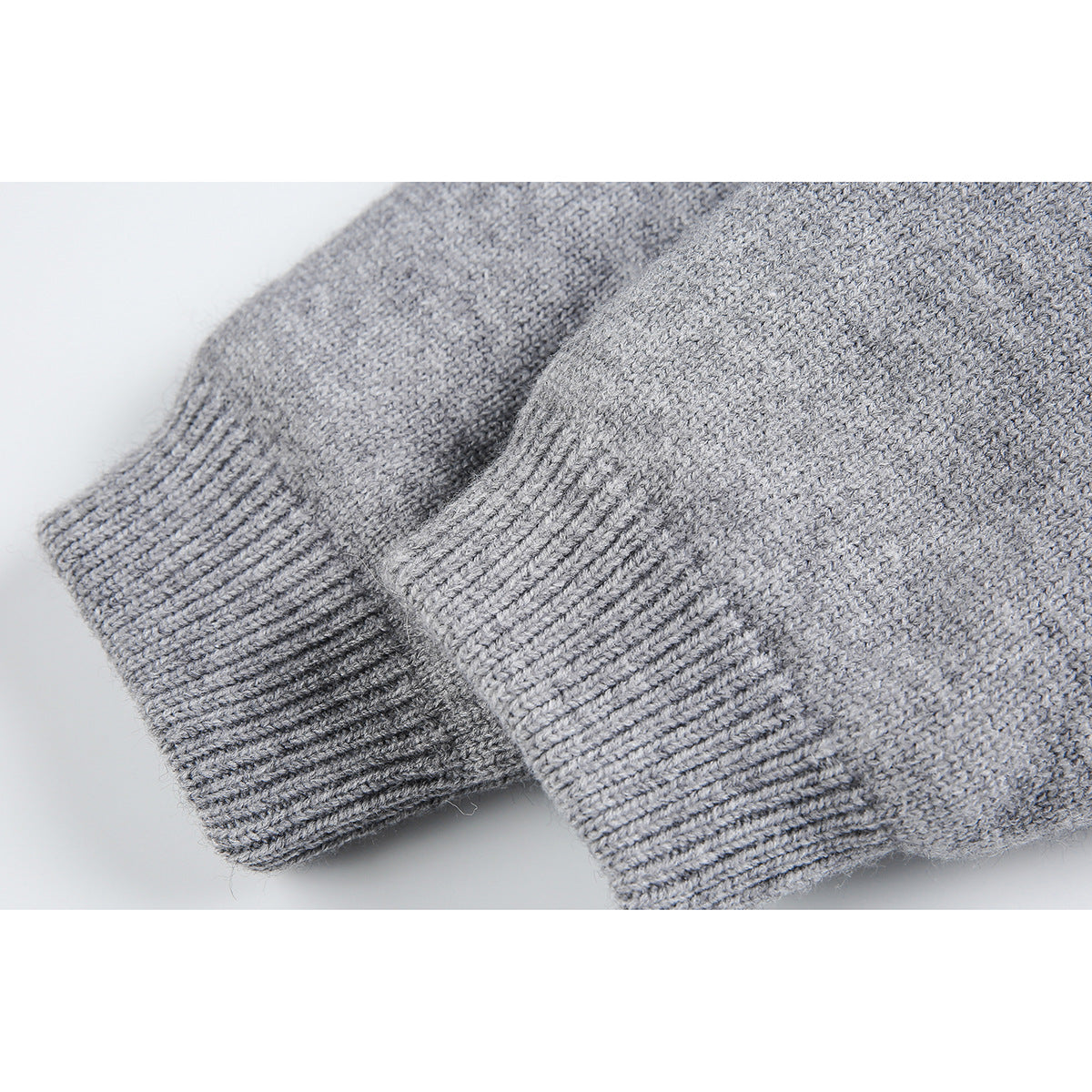 Close-up of two light gray knit hoodie cuffs with ribbed edges and visible knit texture.
