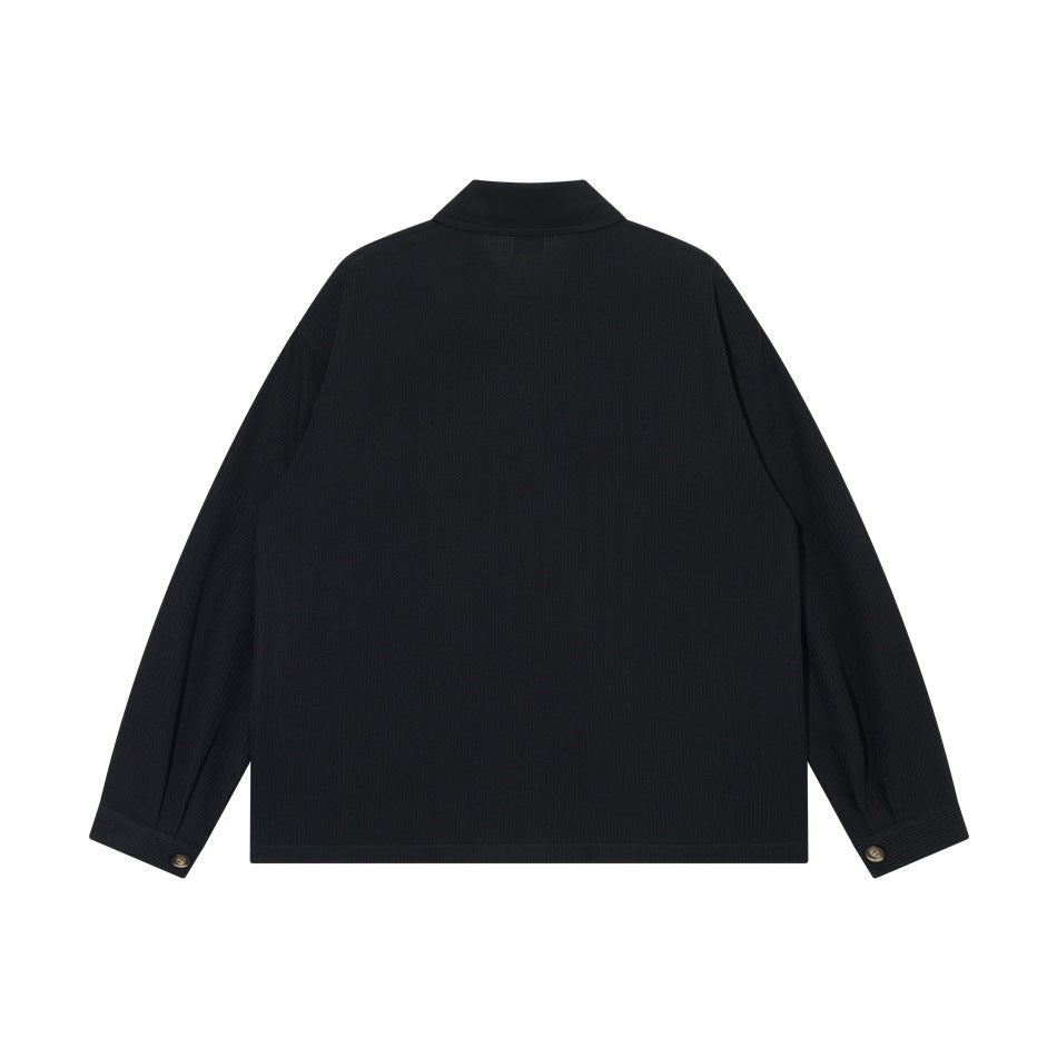 Back view of black jacket with ribbed texture, collar and buttoned cuffs