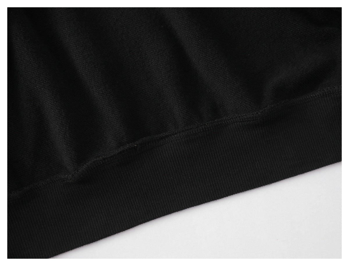 Close-up of black fabric joined to a wide ribbed hem with visible stitching.