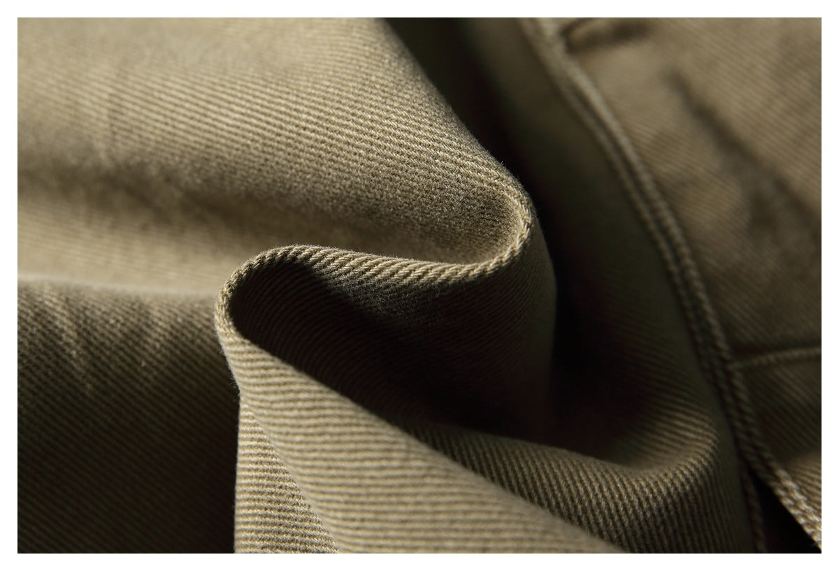 Close-up of khaki twill trouser fabric folded to show its diagonal weave and stitching.