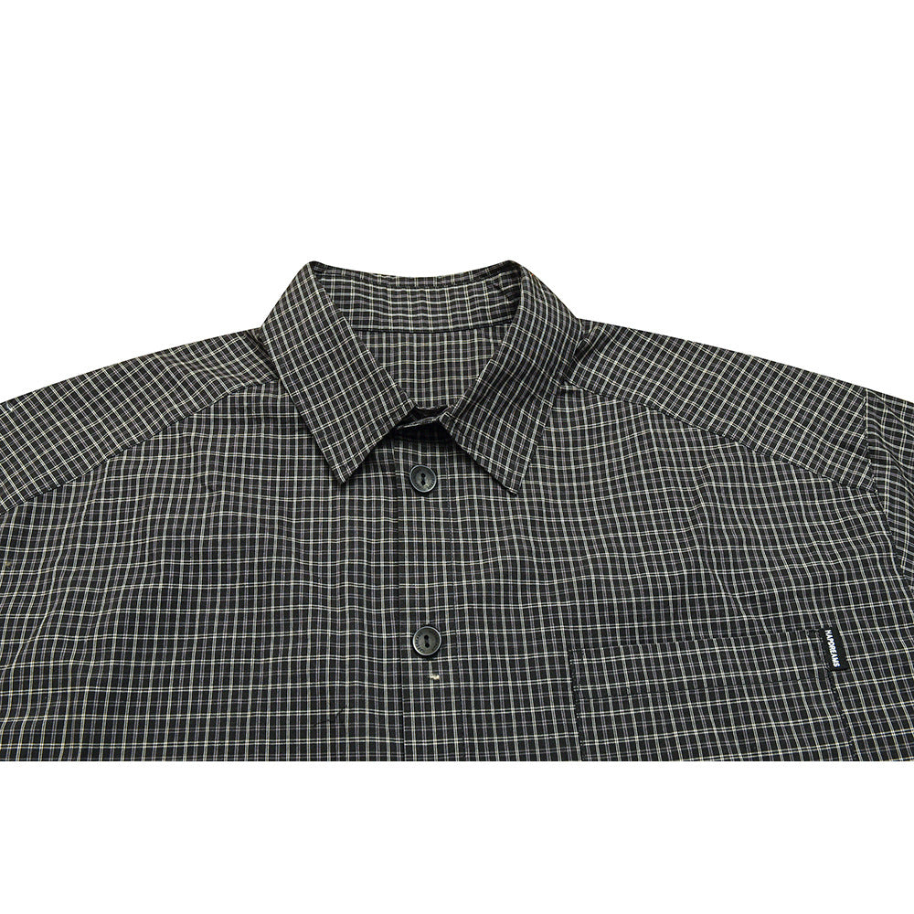 Close view of a dark plaid button-up shirt showing its pointed collar, buttons, and chest pocket.