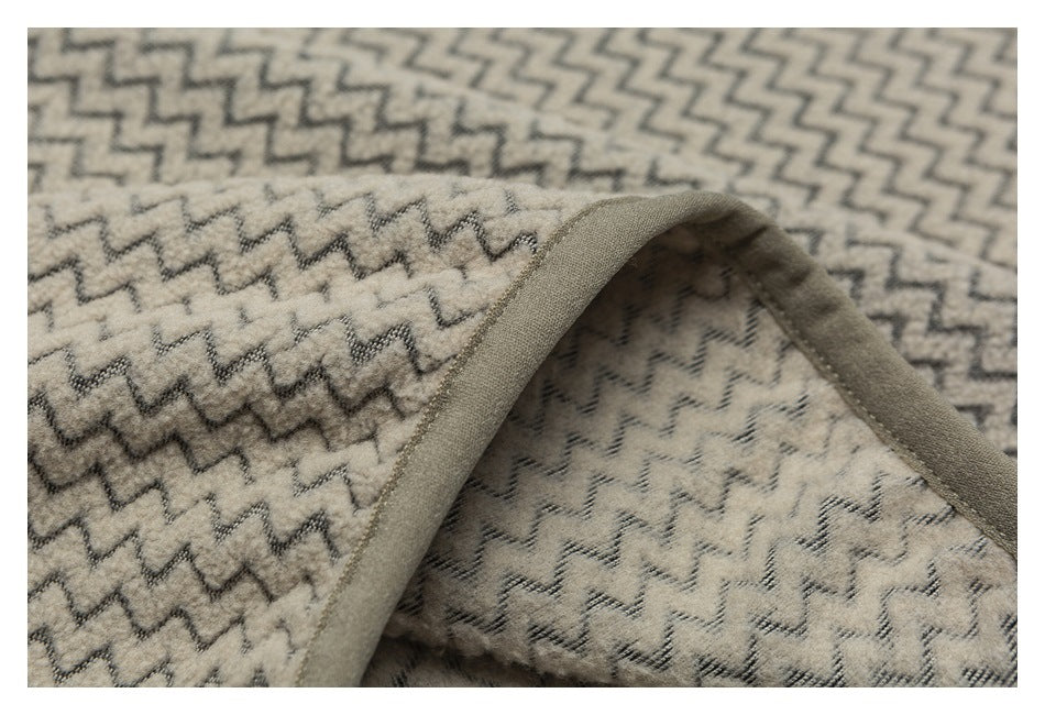 Close-up of the garment's patterned fabric and taupe-bound edge, showing the inside surface.