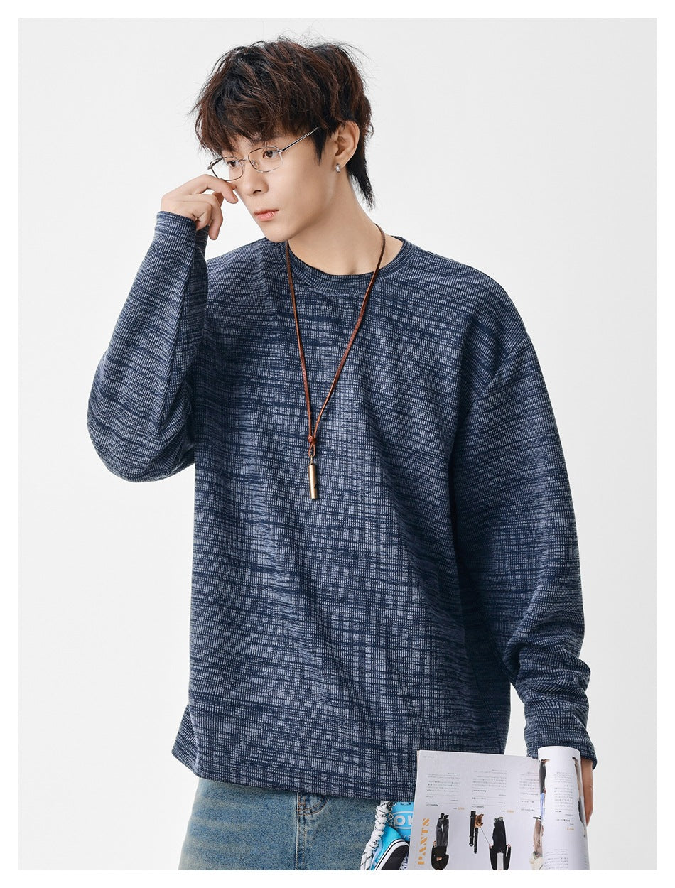 Model wearing a navy marled crewneck sweatshirt with long sleeves and a relaxed fit.