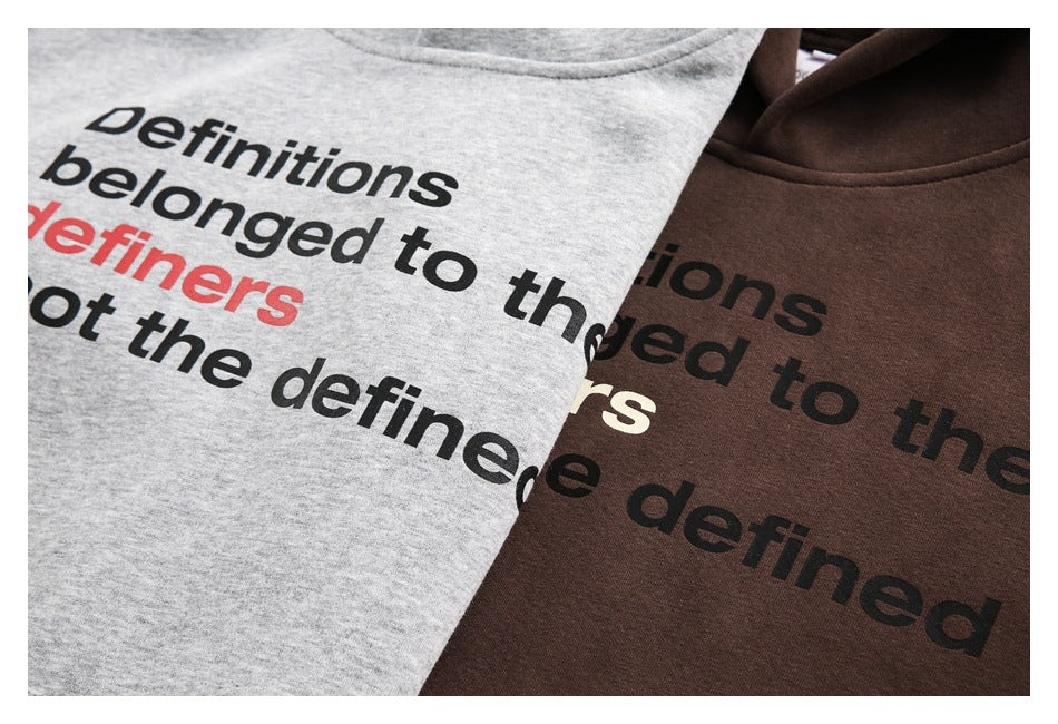 Close-up of gray and brown sweatshirt fronts with bold printed English text in black and red.