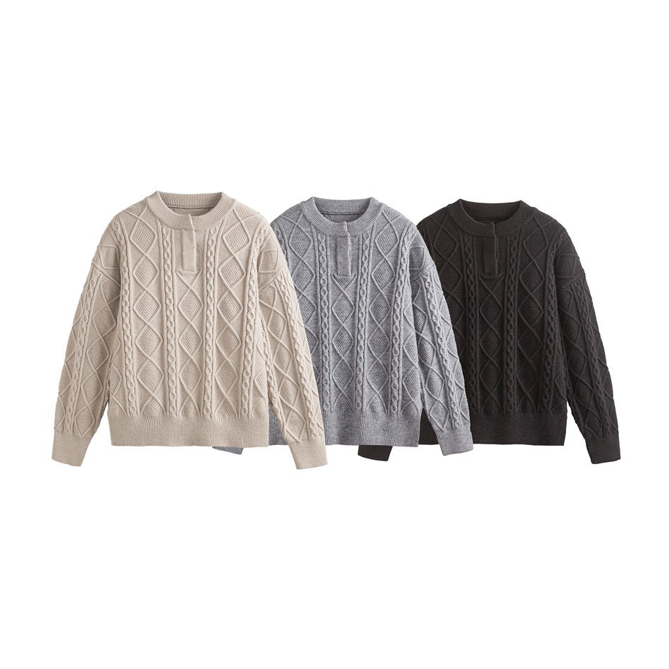 Three flat-laid cable-knit sweaters shown in cream, gray, and black.