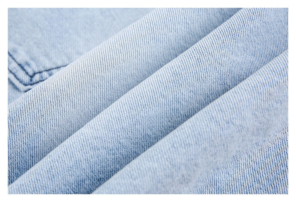 Macro view of the diagonal weave and light blue wash of denim fabric.