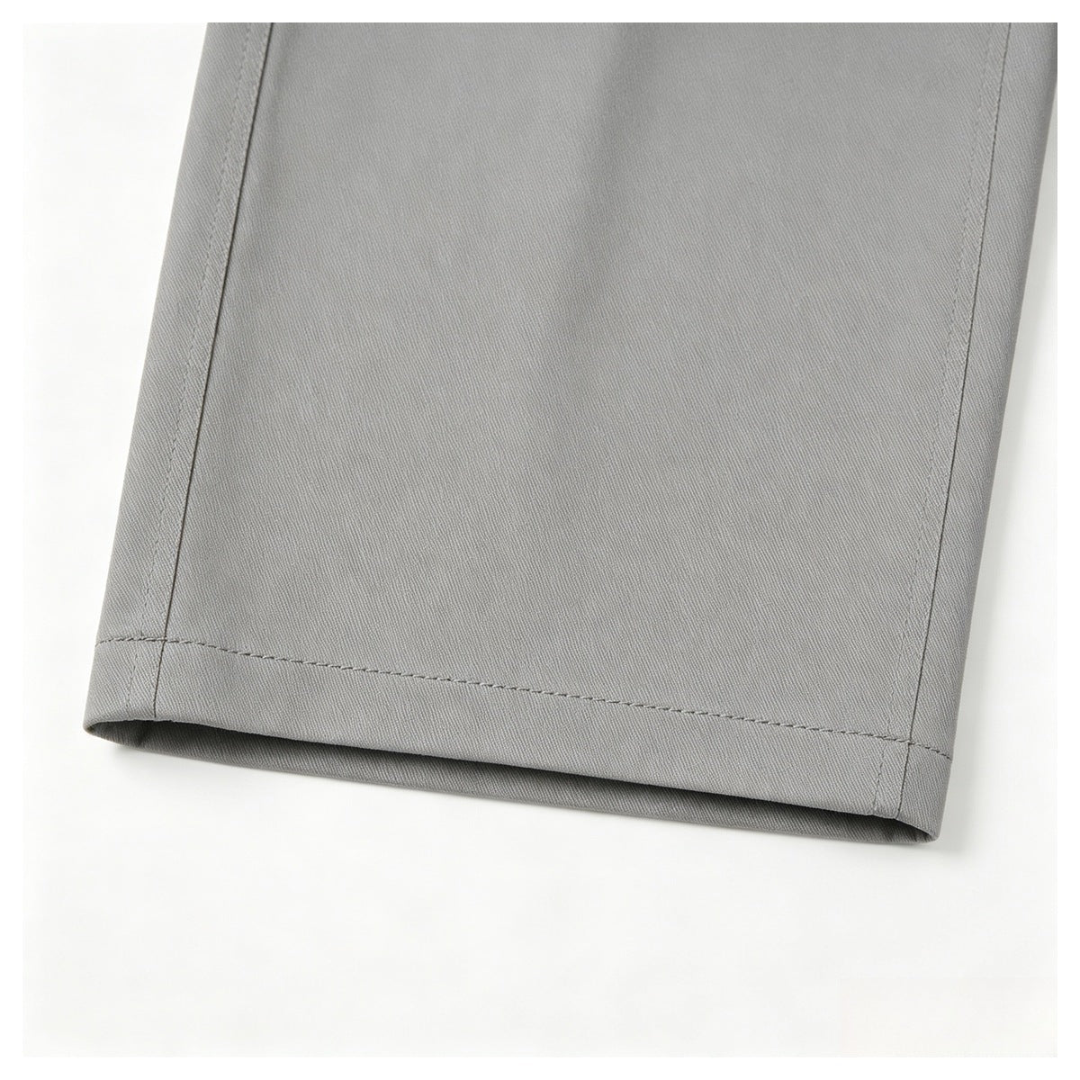 Close-up of a straight stitched hem on light gray fabric.
